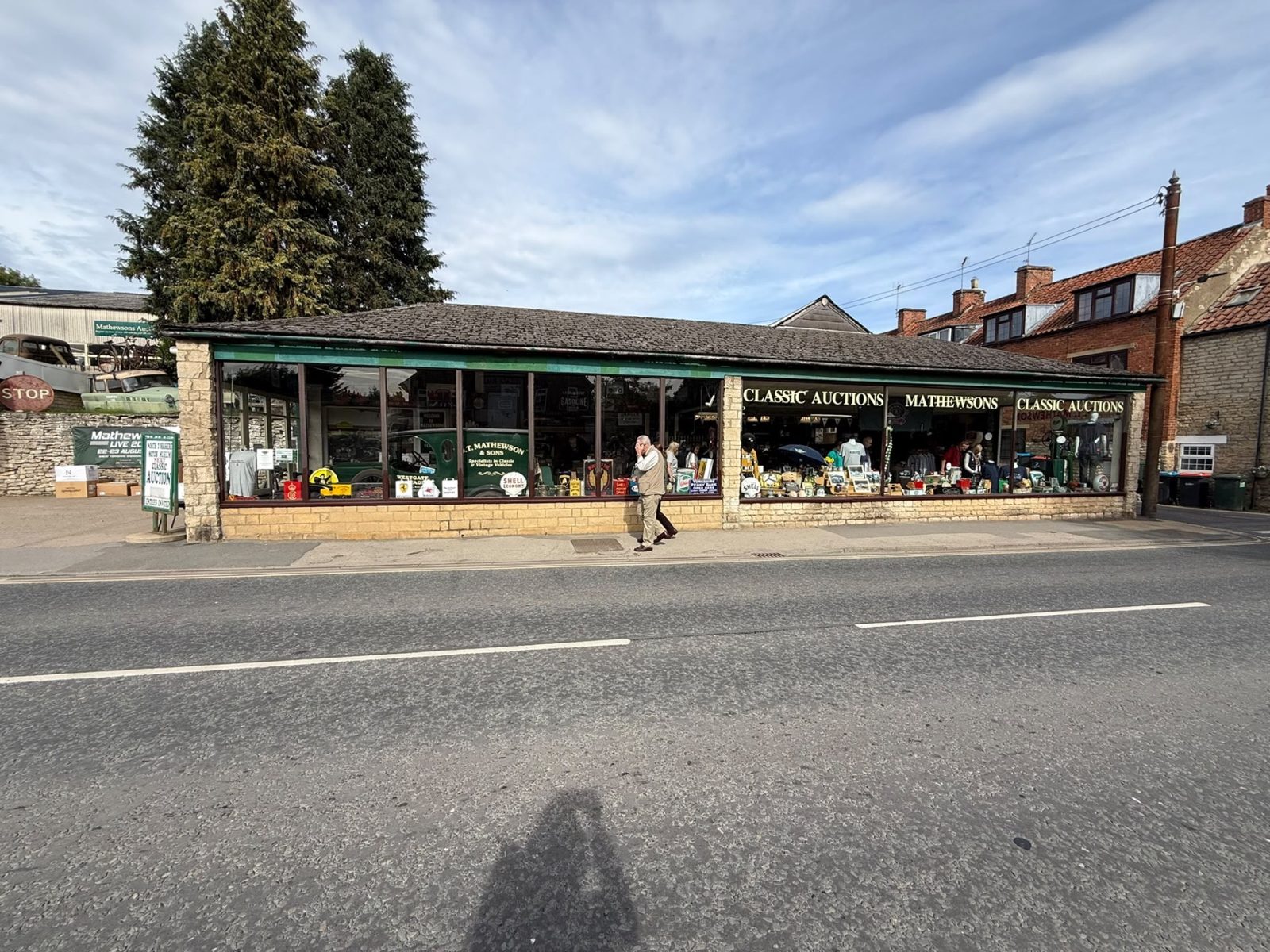 The long, low Mathewsons building on Pickering Road in Thornton-le-Dale seen from across the road, its green fascia reading Classic Auctions and Mathewsons above a run of shop windows