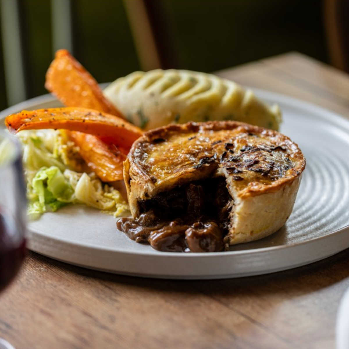 A meat pie with mash, cabbage and glazed carrots at The Buck