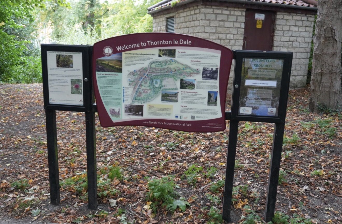 A North York Moors National Park board reading Welcome to Thornton le Dale, with a map of the village