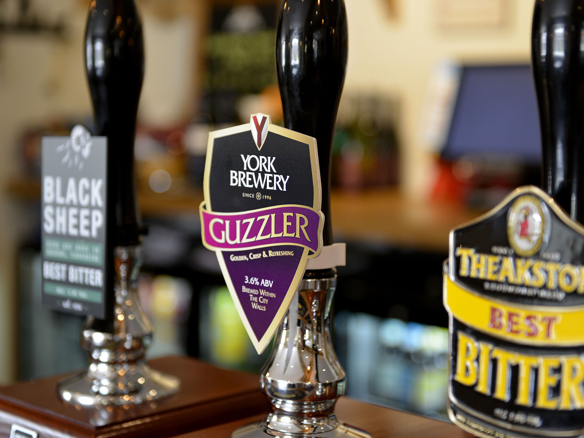 Hand pulls on the bar at the Cayley Arms with pump clips for York Brewery Guzzler, Black Sheep Best Bitter and Theakston Best Bitter