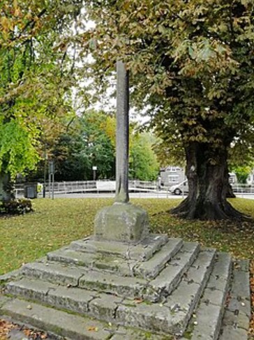 The medieval market cross and old village stocks on the green at Thornton-le-Dale